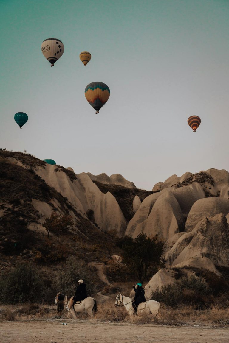Hot air balloons soar over Cappadocia's unique rock formations at sunrise, offering a breathtaking adventure.